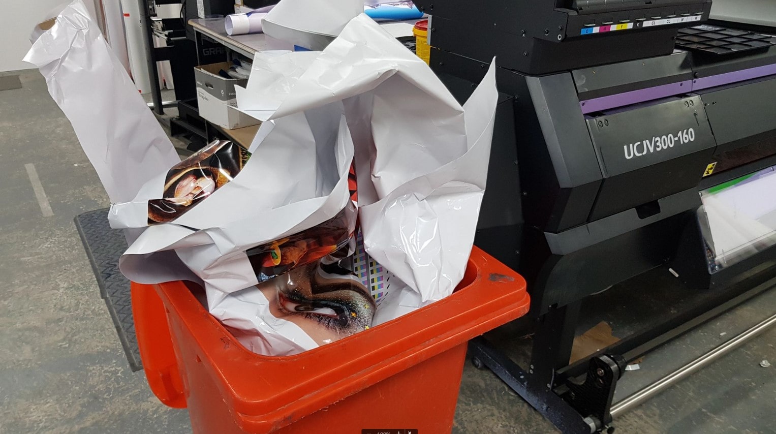 A red bin full of wasted supplies in a print supplier business. 