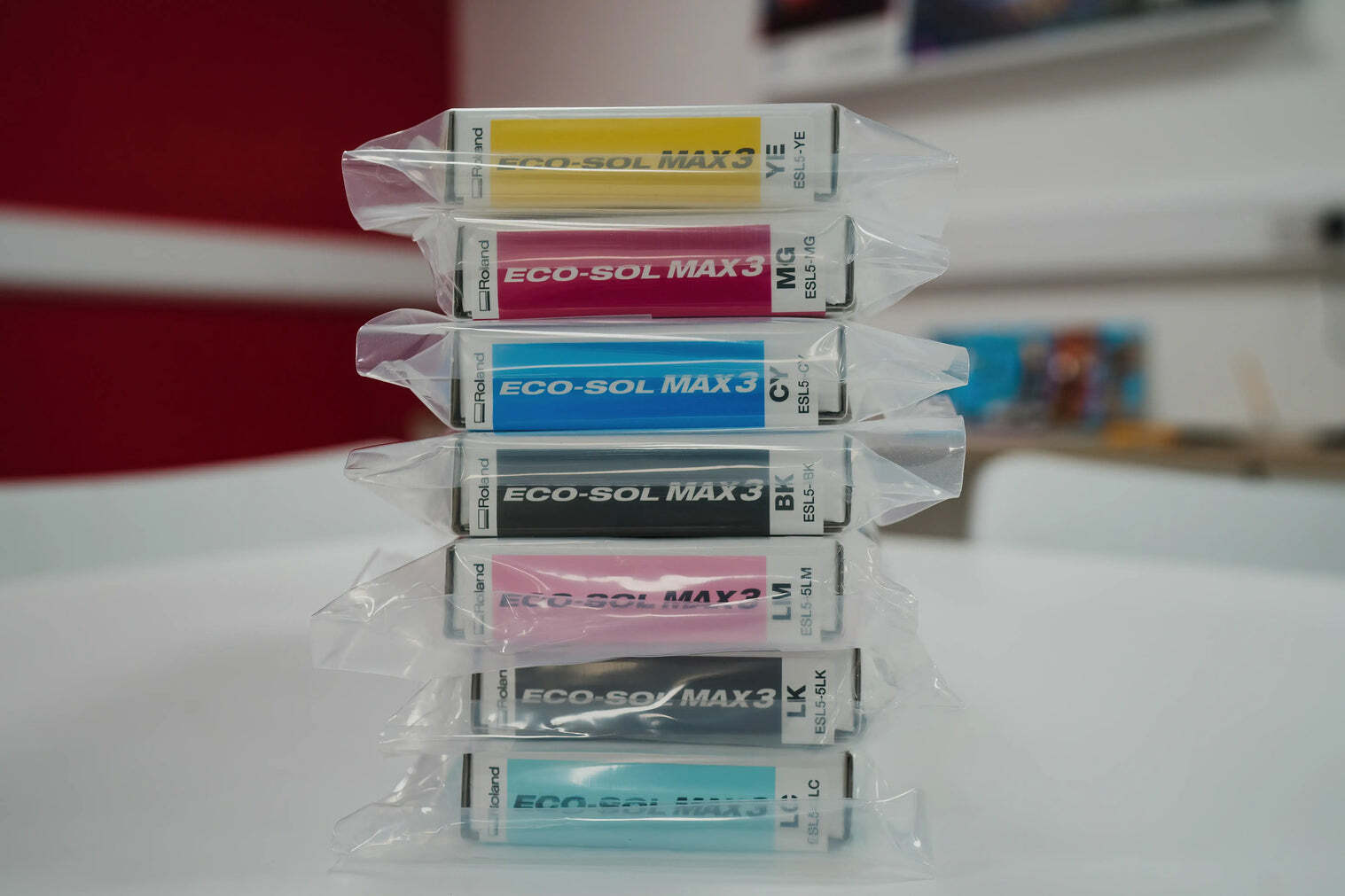 Roland EcoSol Max Ink cartridges (ESL3, ESL4, ESL5) stacked, showcasing eco-solvent printing supplies for professional wide format printers. 